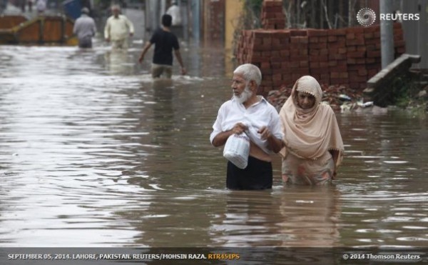 A couple wades through a flooded road after heavy rains in Lahore, Pakistan, on September 4, 2014. REUTERS/Mohsin Raza