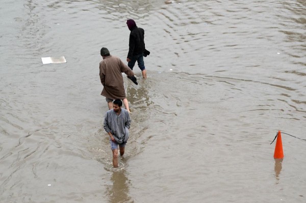 SRINAGAR, INDIA-MARCH 29 : Kashmiri muslims cross a waterlogged street in city center Lal chowk in Srinagar the summer capital of Indian administered Kashmir on March 29,2015 .The valley has been witnessing heavy rainfall since Saturday, leading to a fresh floods panic and sudden surge in water level in rivers, streams and rivulet across Kashmir. Photo: AA